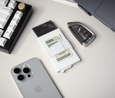 Slim minimalist wallet with cash, phone, and car key — compact everyday carry setup for modern men.