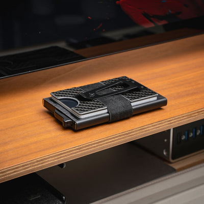 Minimalist carbon fiber wallet on wooden surface — slim, RFID-blocking design for modern everyday carry.