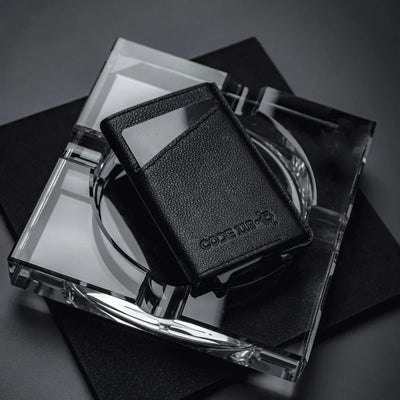 “High-quality black leather wallet on glass display – premium minimalist leather wallet for men with slim design.”