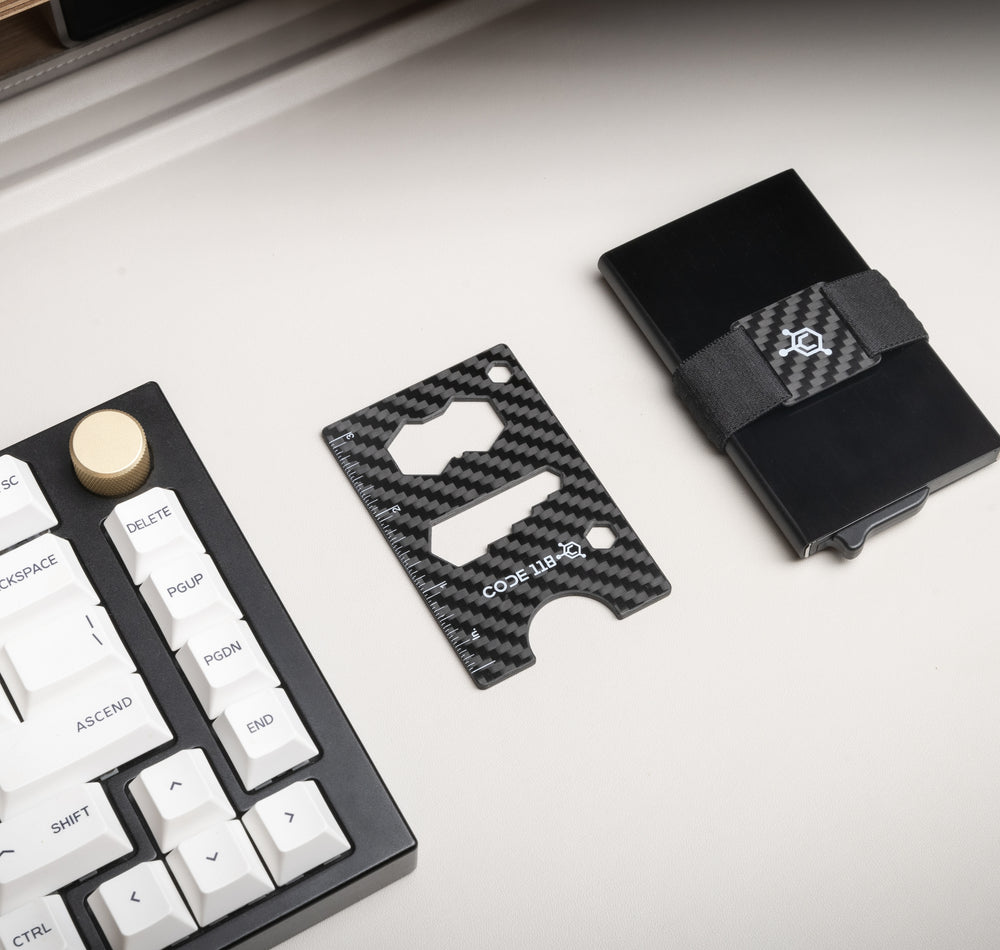 Carbon fiber Multi-Tool Card beside a CODE 118 wallet, showing the tool openings and compact size