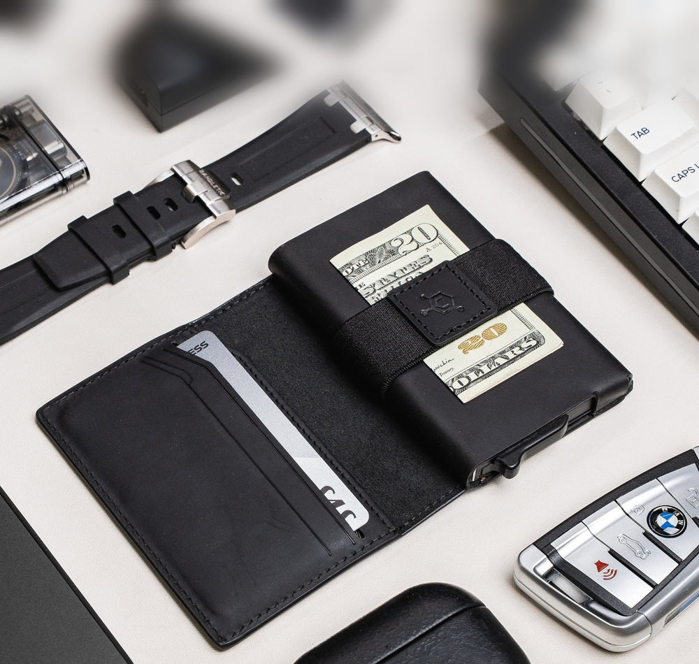 Open black CODE 118 Bi-Fold Leather Case on a desk with a card in its inner pocket and cash under the strap